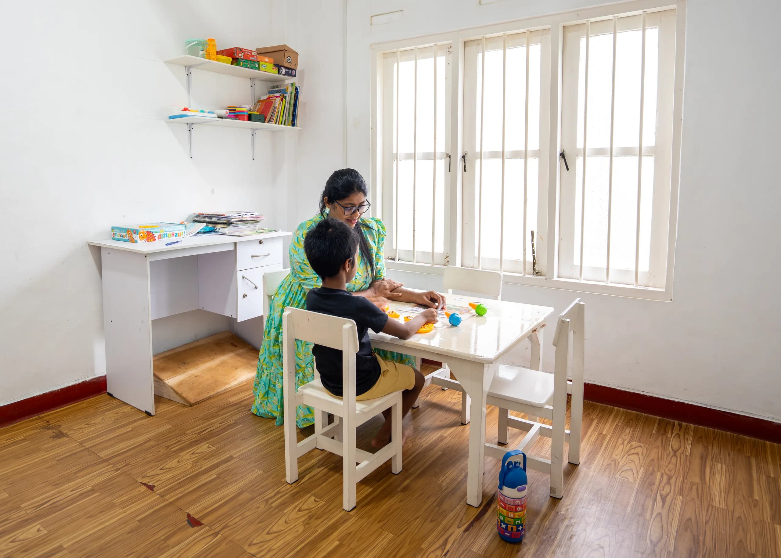Therapist supporting a child at the activity table